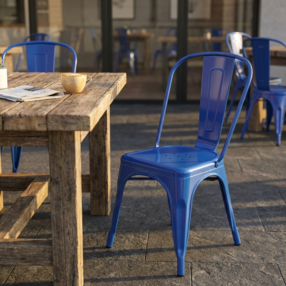 Sedia Lola blu in metallo lucido posizionata accanto a un tavolo rustico in un caffè.