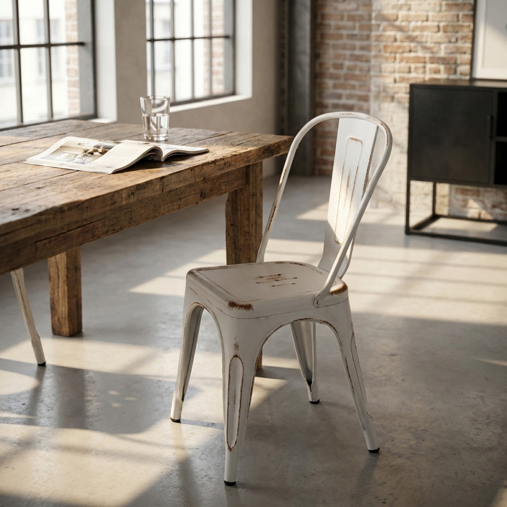 Sedia Lola in acciaio bianco antico ambientata in una sala da pranzo dal design industriale con tavolo in legno.