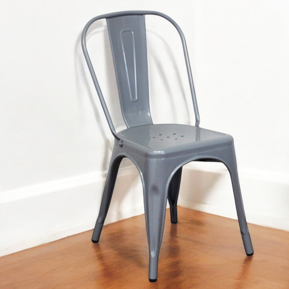 Sedia Lola Grigia ambientata in un angolo minimalista con pavimento in legno e pareti bianche.