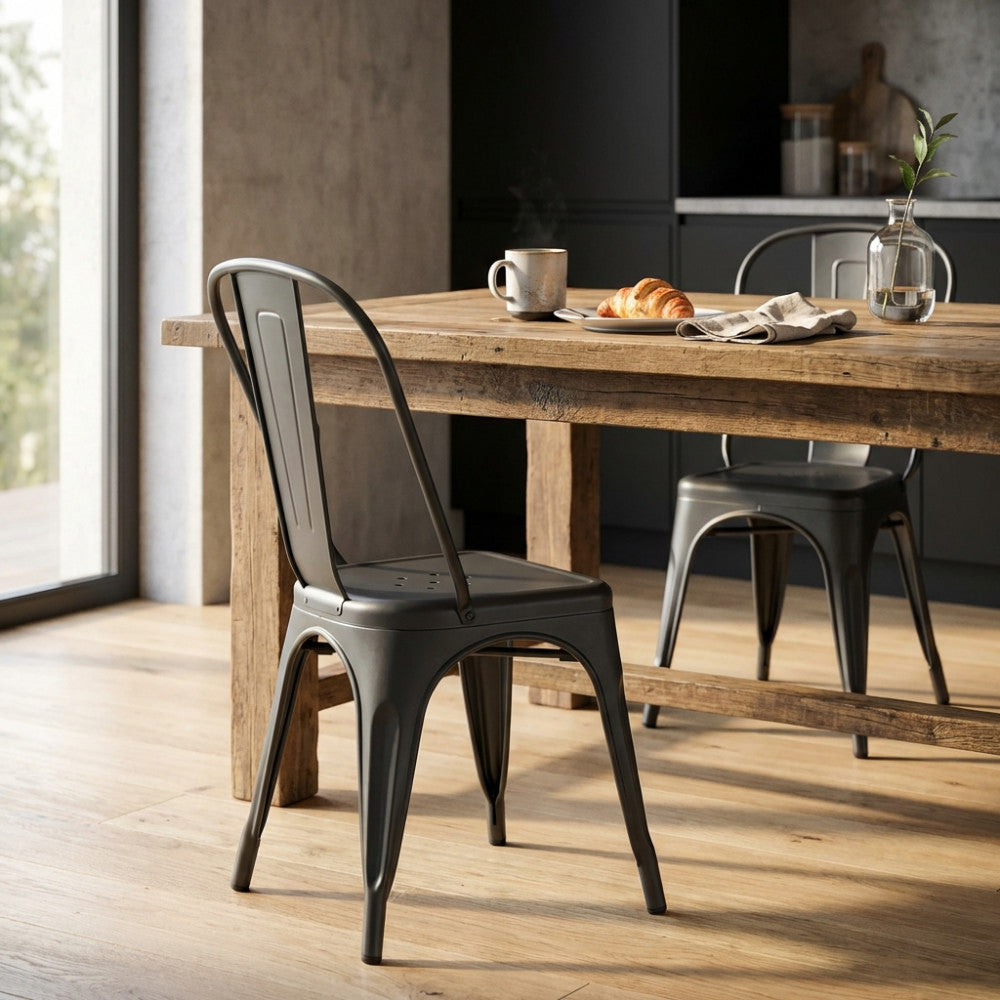 Sedia Lola grigio scuro posizionata in una sala da pranzo moderna accanto a un tavolo in legno rustico.