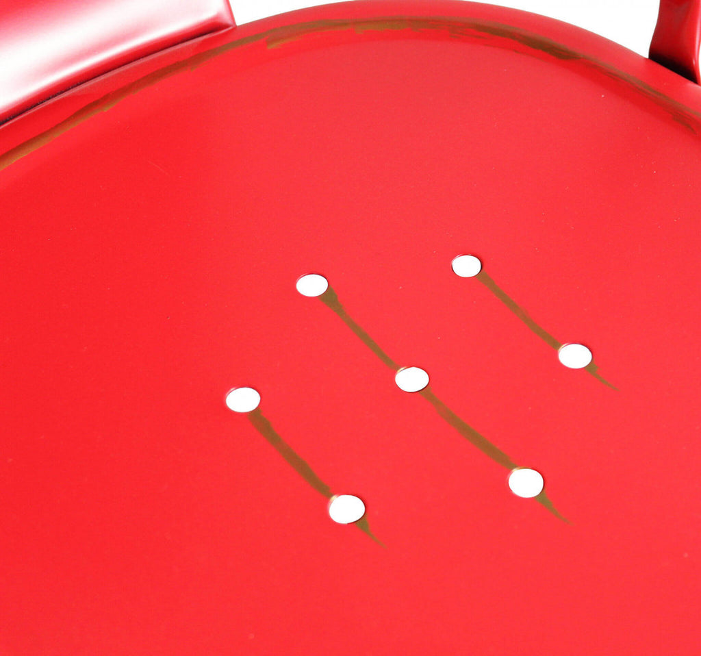 Particolare della seduta in acciaio della sedia Lola Red Antico, che mostra i fori decorativi e l'effetto vissuto.