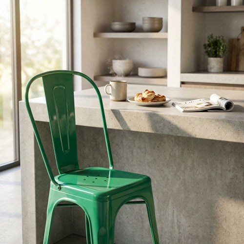 Sedia Lola verde posizionata in una cucina moderna accanto a un'isola in cemento.