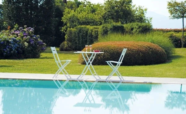 Sedia Lucca Pieghevole in Alluminio Bianco con design a listelli, resistente e salvaspazio per esterni, ambientata a bordo piscina