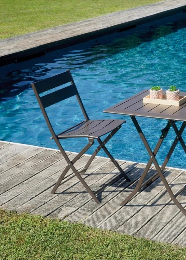 Sedia Lucca Pieghevole in Alluminio Chocolate con design a listelli, resistente e salvaspazio per esterni, ambientata esterna