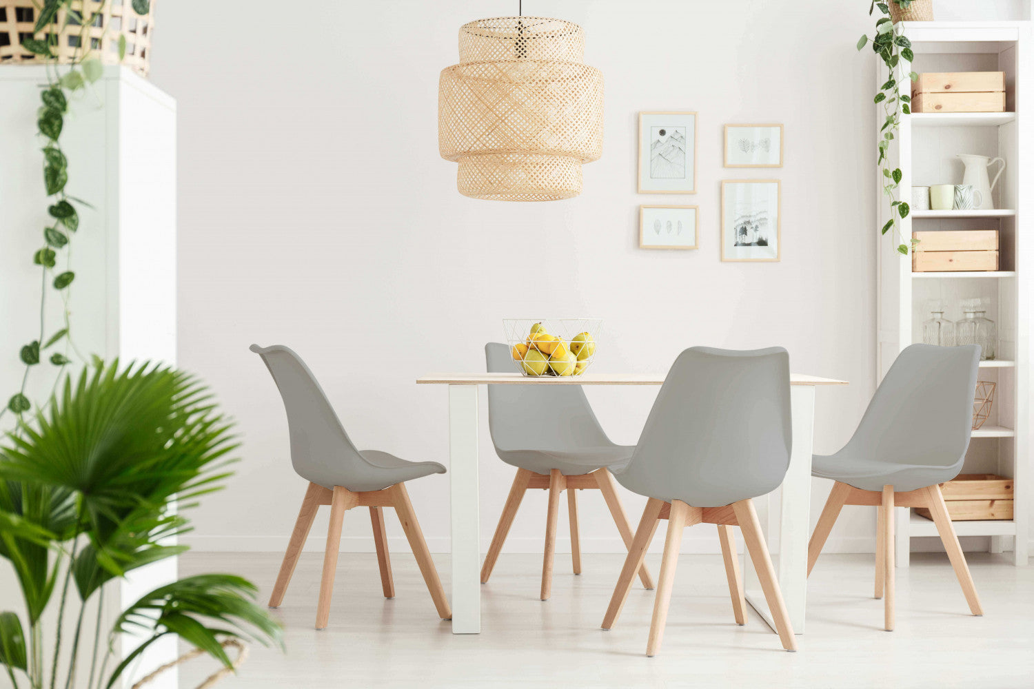 Set di Sedie Marsiglia attorno a un tavolo bianco in una sala da pranzo luminosa e ariosa con lampadario in rattan.