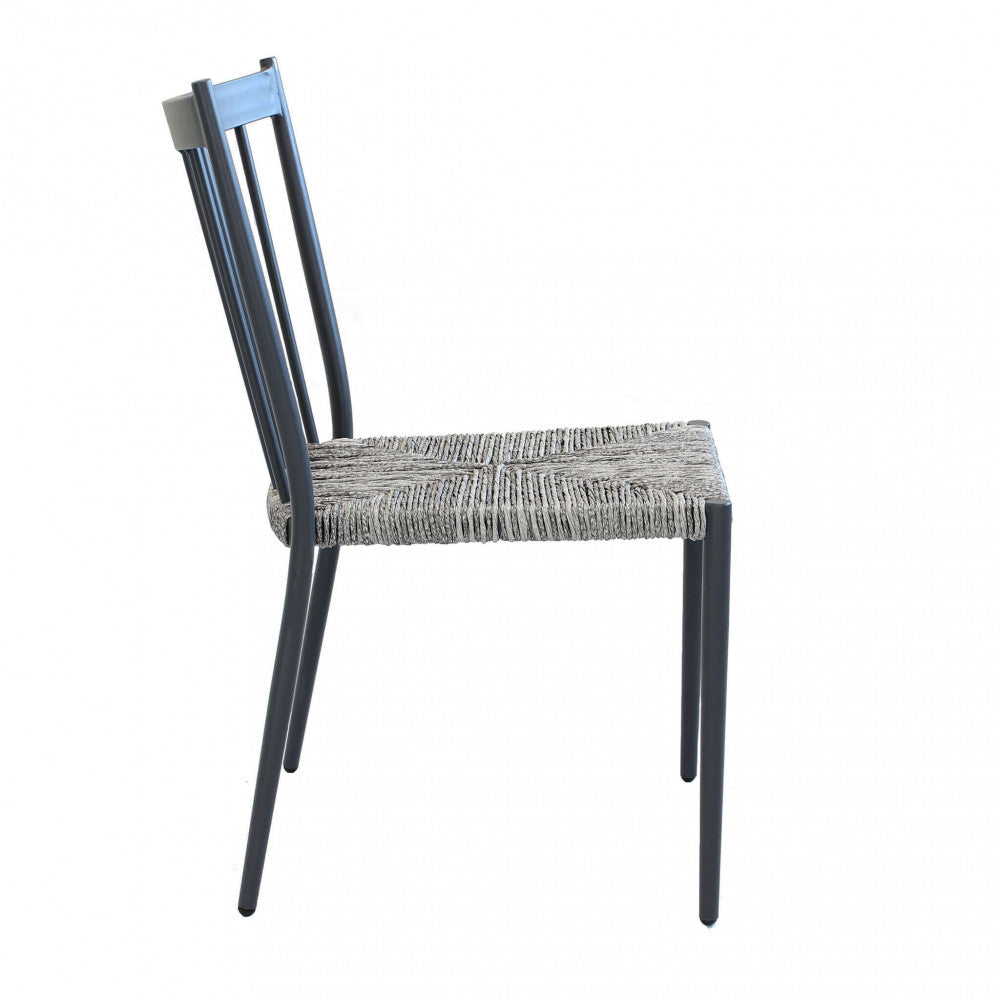 Profilo laterale della sedia in alluminio e wicker, che sottolinea la curvatura ergonomica dello schienale e la seduta intrecciata.