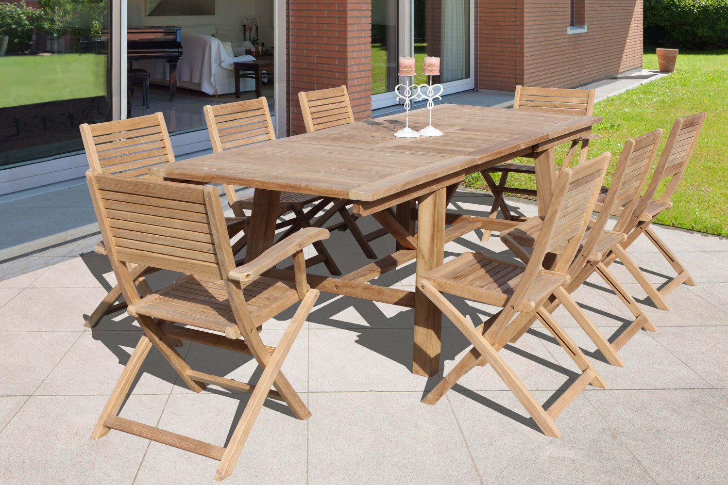 Set da pranzo outdoor composto da un grande tavolo rettangolare e otto sedie Mirage pieghevoli in teak su una terrazza pavimentata.