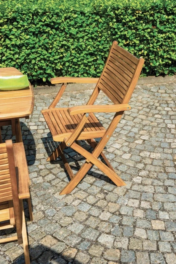 Sedia pieghevole Pietrasanta con braccioli in Legno di Acacia massiccio e design a listelli per esterni, abbinata con tavolo