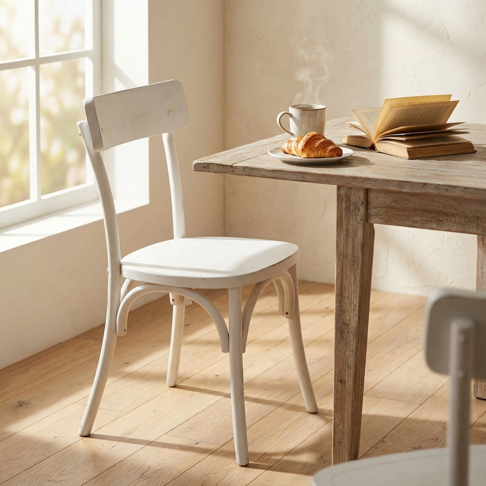Sedia Polly in ambientazione luminosa accanto a un tavolo in legno rustico con colazione.
