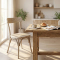 Sedia Polly Naturale in legno di olmo ambientata in una luminosa sala da pranzo dal design rustico.