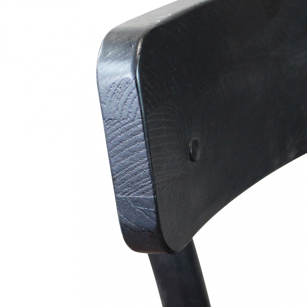 Primo piano del dettaglio dello schienale in legno nero anticato, evidenziando la venatura materica e il rivetto metallico.