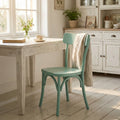 Sedia Polly verde in stile shabby chic posizionata accanto a un tavolo bianco in una sala da pranzo luminosa.