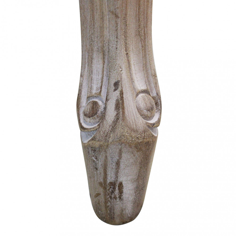 Dettaglio del piedino della gamba anteriore della Sedia Romy, che mostra la finitura anticata del legno.