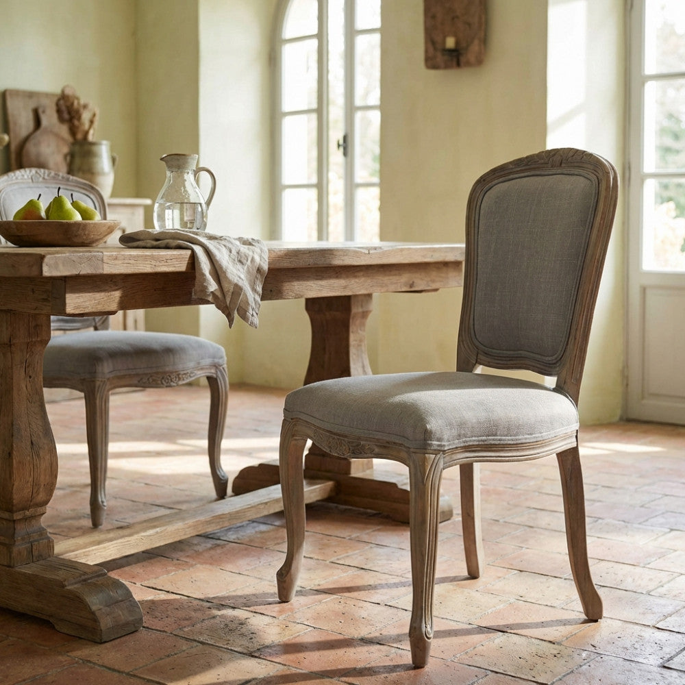 Sedia Romy in legno e tessuto grigio posizionata in una luminosa sala da pranzo con pavimento in cotto.