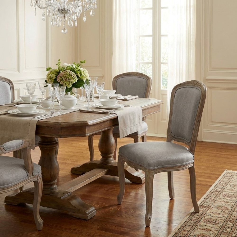Set di Sedie Romy disposte attorno a un grande tavolo da pranzo classico sotto un lampadario di cristallo.