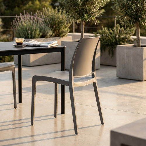 Sedia Volga in polipropilene grigio chiaro posizionata su una terrazza moderna al tramonto.