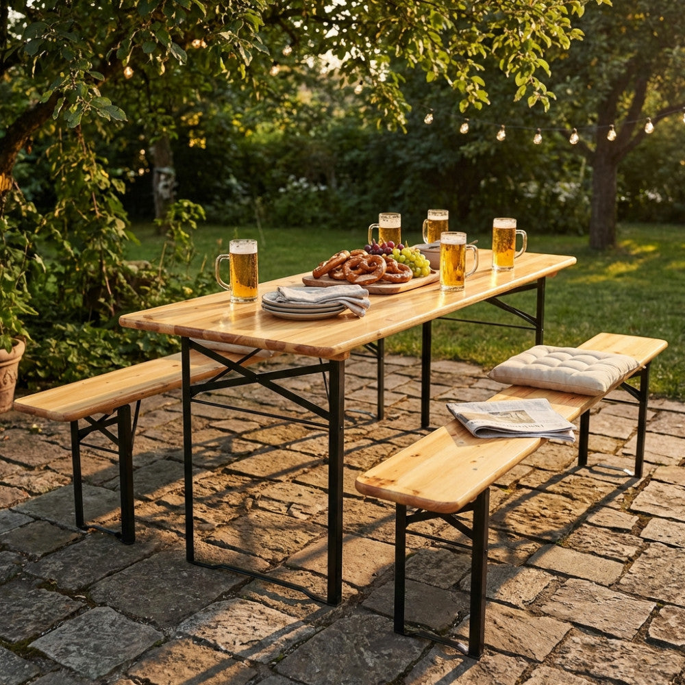 Dettaglio del tavolo da giardino pieghevole in legno con panche, immerso nella luce dorata di un cortile alberato.