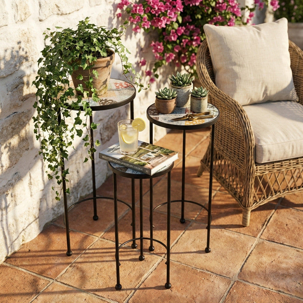 Set di tre fioriere rotonde in ceramica azzurra multicolor disposte su un patio in cotto, affiancate da una poltrona in midollino e piante decorative.