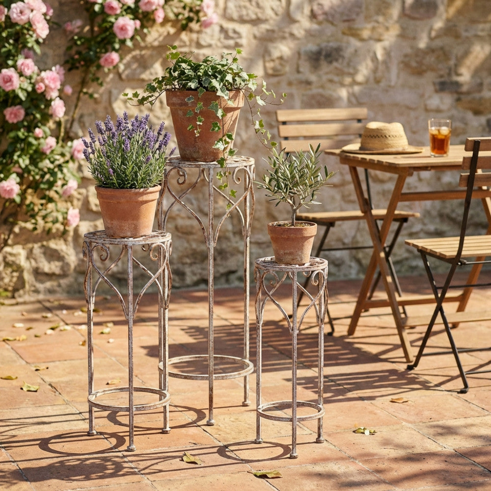 Fioriere Valerie in metallo posizionate in un cortile esterno in pietra con lavanda e piante decorative.