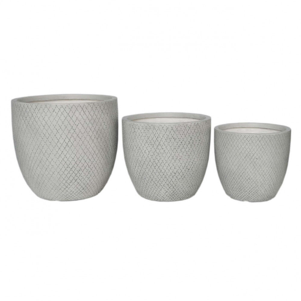 Tre vasi vuoti in fibra di argilla grigia con pattern a rombi disposti in ordine di grandezza su sfondo bianco.