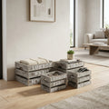 Set di 4 cassette in legno grigio Nicole disposte a terra in un soggiorno luminoso, utilizzate per riporre coperte e telecomandi.