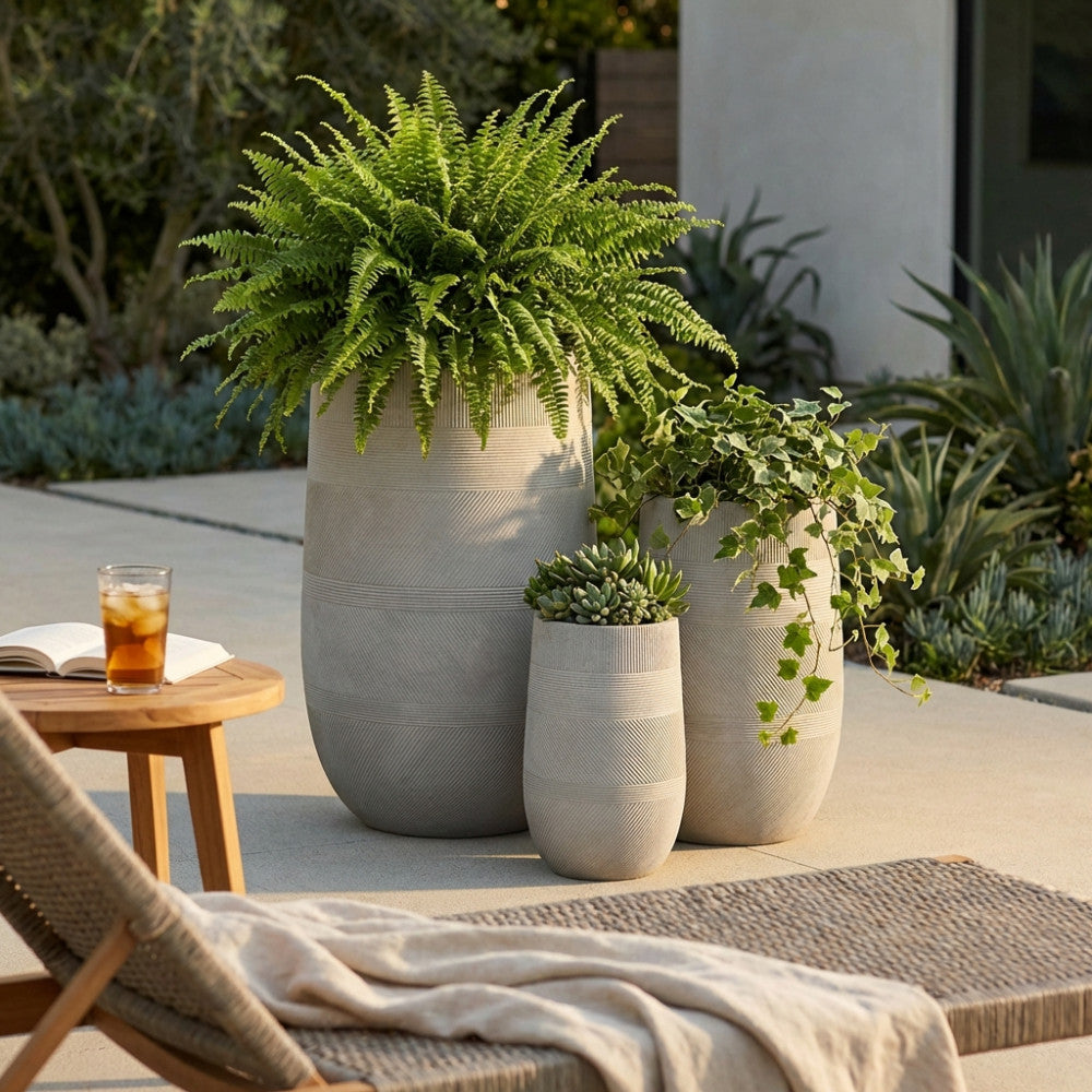 Set di vasi Fiordaliso da esterno con piante rigogliose su una terrazza soleggiata dal design contemporaneo.