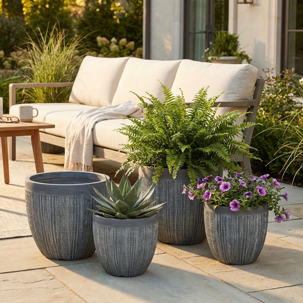 Dettaglio del Set Vasi Garofano in ambiente outdoor, con felci e fiori che contrastano elegantemente con la texture intrecciata grigia.