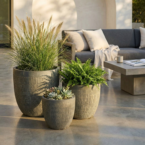 Tre vasi Set Pesco in fibra sintetica marrone con piante decorative su un patio moderno.