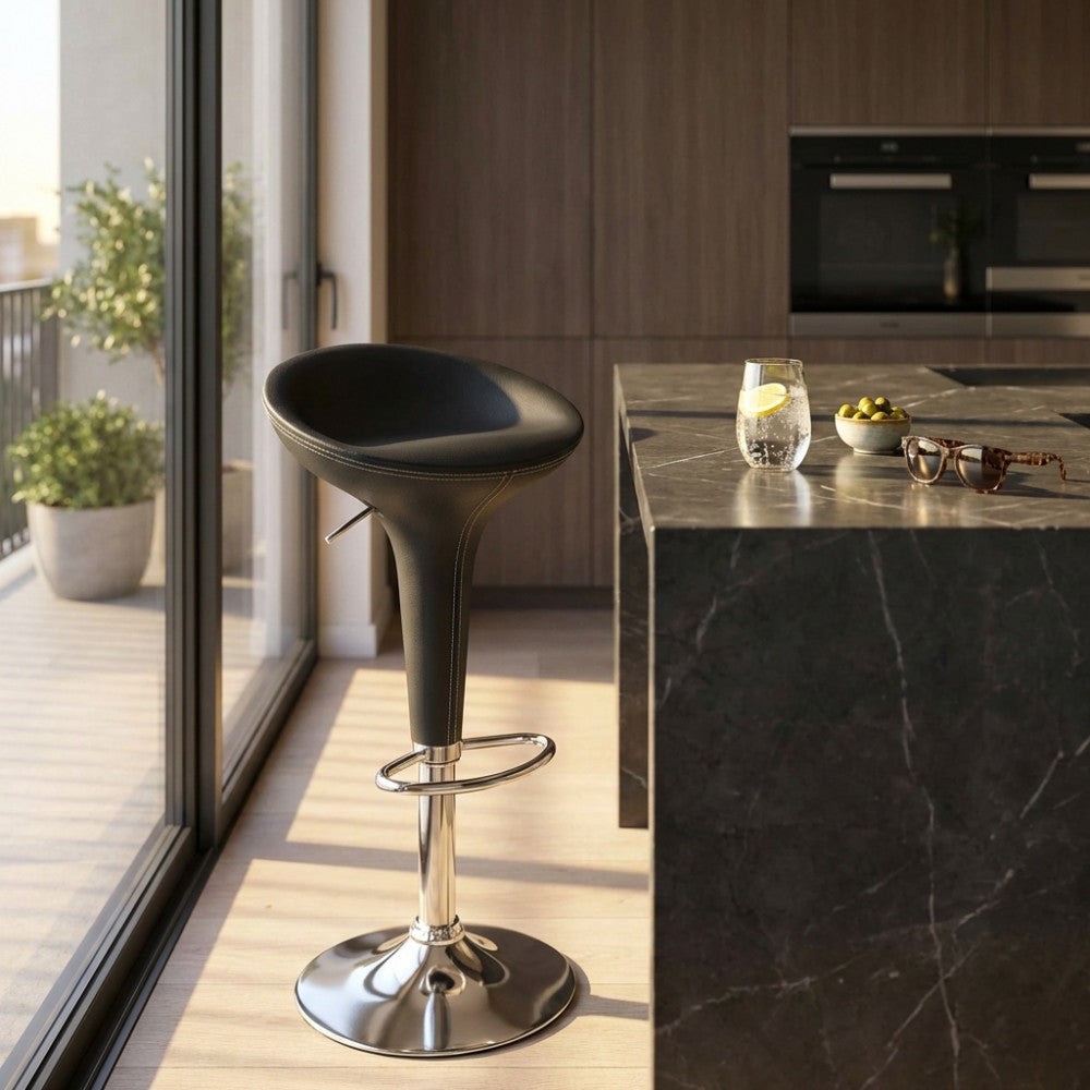 Sgabello Jago grigio posizionato accanto a un'elegante isola cucina in marmo scuro.
