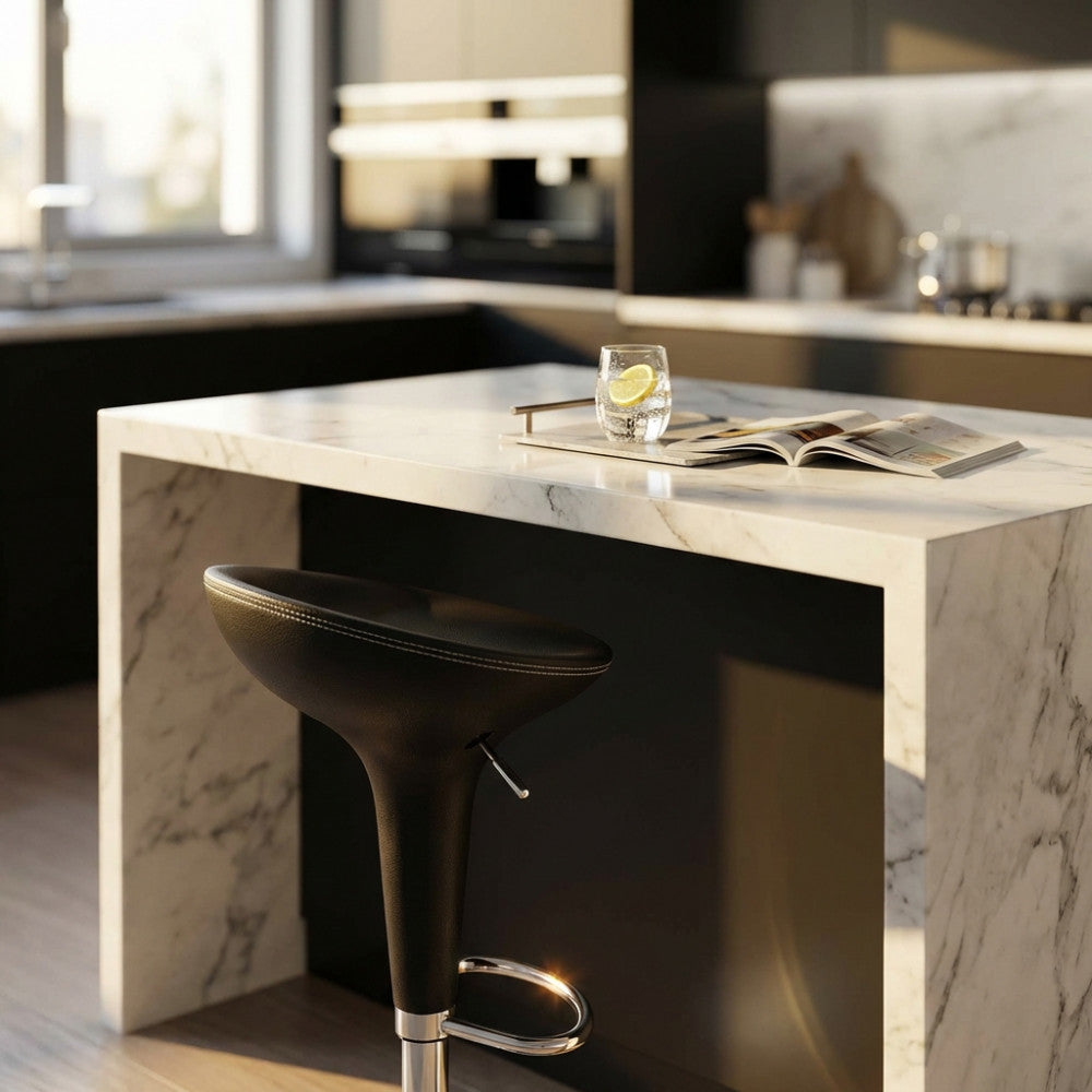 Dettaglio dello sgabello Jago accostato a un'elegante isola cucina in marmo bianco.