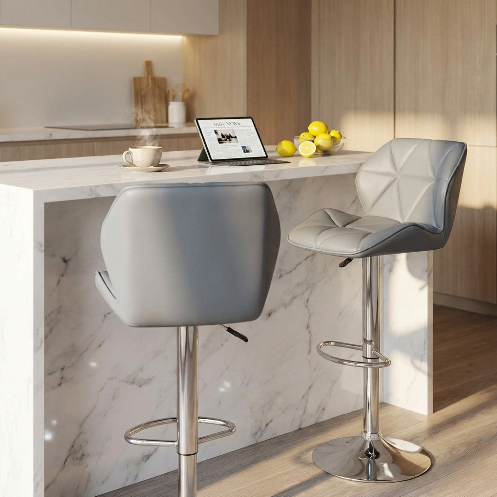 Coppia di sgabelli Manuel grigi posizionati accanto a un'elegante isola cucina in marmo bianco.