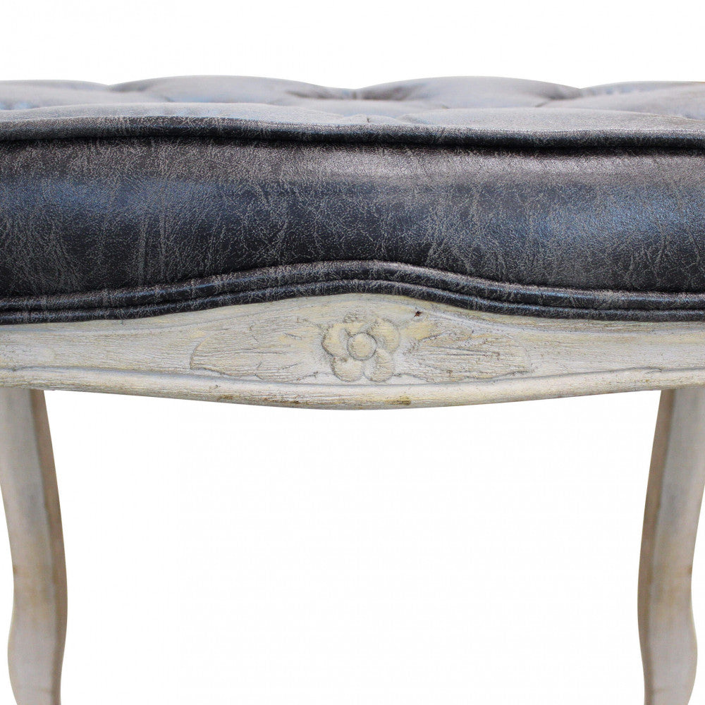 Dettaglio ravvicinato della fascia in legno intagliato con motivo floreale dello sgabello Marly.
