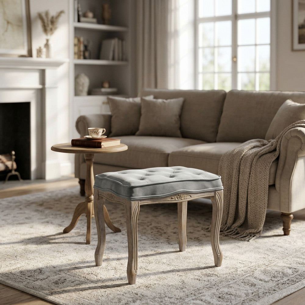 Sgabello Marly in legno e velluto grigio posizionato in un living luminoso dai toni neutri.