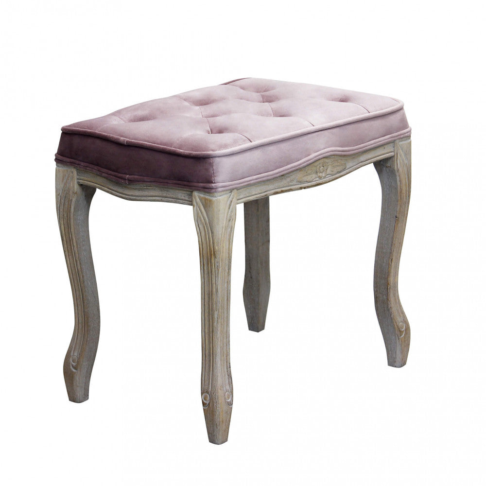 Vista angolare dello sgabello Marly, che evidenzia la seduta capitonné in velluto rosa e le gambe in legno intagliato.