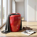 Sgabello pouf rosso lucido con coperta grigia appoggiata, situato in un soggiorno luminoso con pavimento in legno.