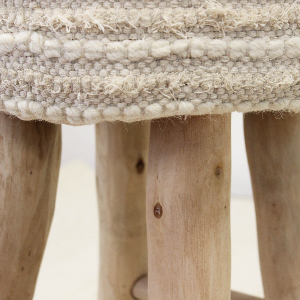 Particolare dell'attacco tra la morbida seduta in tessuto e le robuste gambe in legno di eucalipto naturale.