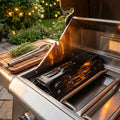 Spargifiamma per barbecue in metallo smaltato installato all'interno di un grill a gas in acciaio inossidabile, illuminato da luci calde.