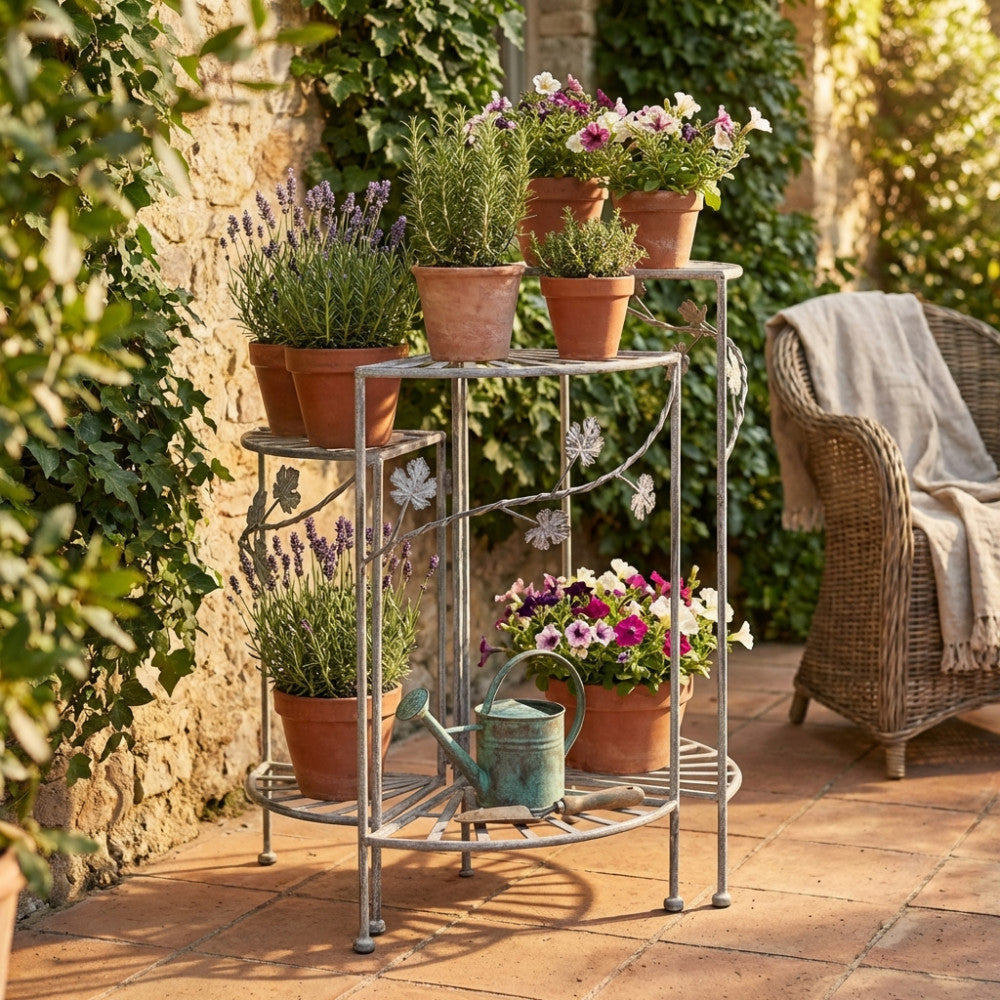 Dettaglio dell'étagère angolare Dominique con vasi di fiori su un patio in cotto.
