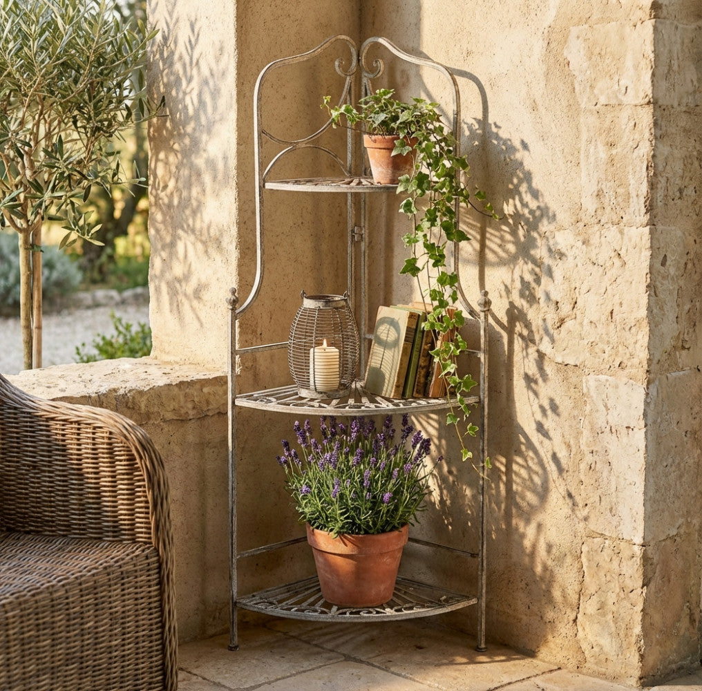 Étagère angolare Rosalie in acciaio bianco ossidato, allestita in un patio rustico con piante di lavanda, edera e una lanterna decorativa.