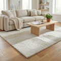 Tappeto moderno in lana bianco beige posizionato in un salotto luminoso con divano chiaro e tavolino in legno.