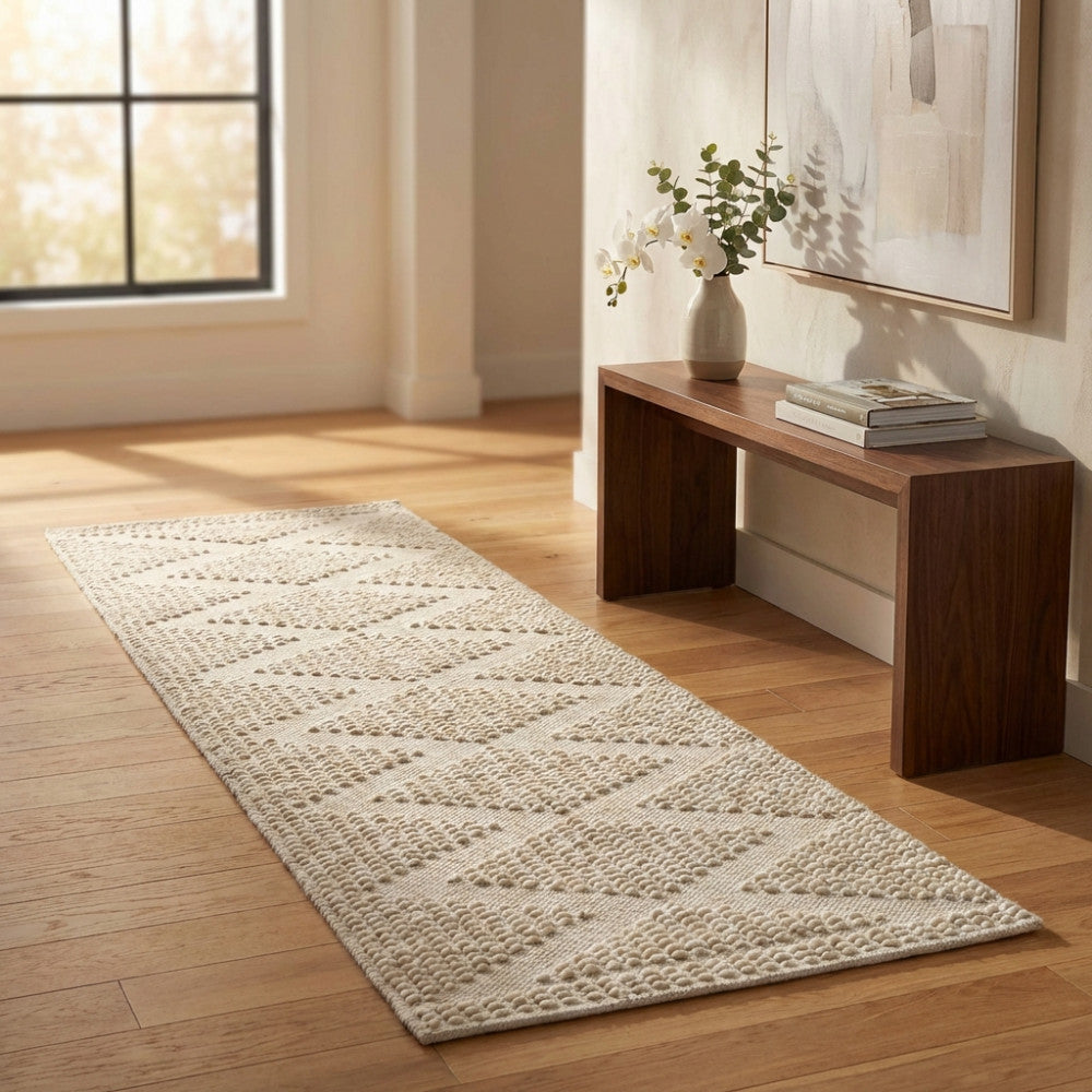 Tappeto Edouard bianco e beige con pattern a rombi in un corridoio luminoso con consolle in legno.