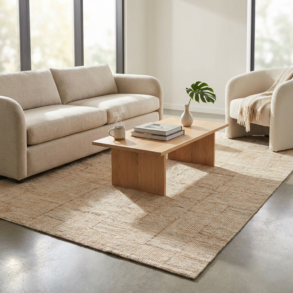 Tappeto Eugène in lana e juta beige ambientato in un soggiorno moderno con divano chiaro e tavolino in legno.