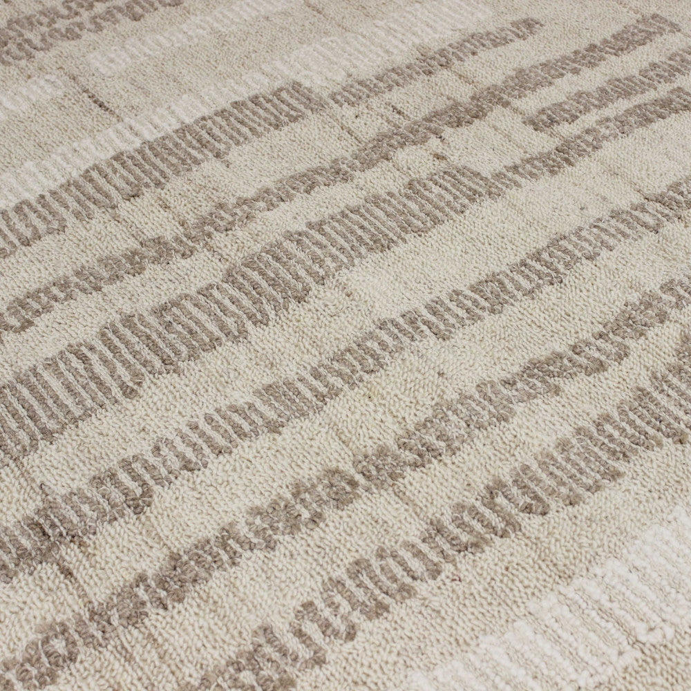 Dettaglio ravvicinato della texture del tappeto Fabien, mettendo in risalto la lavorazione a rilievo in lana, cotone e poliestere.