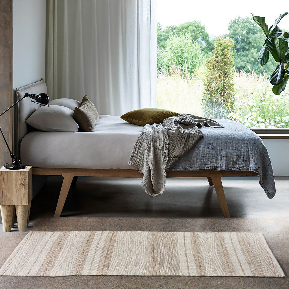 Tappeto moderno Florian posizionato ai piedi di un letto in una camera dal design contemporaneo.
