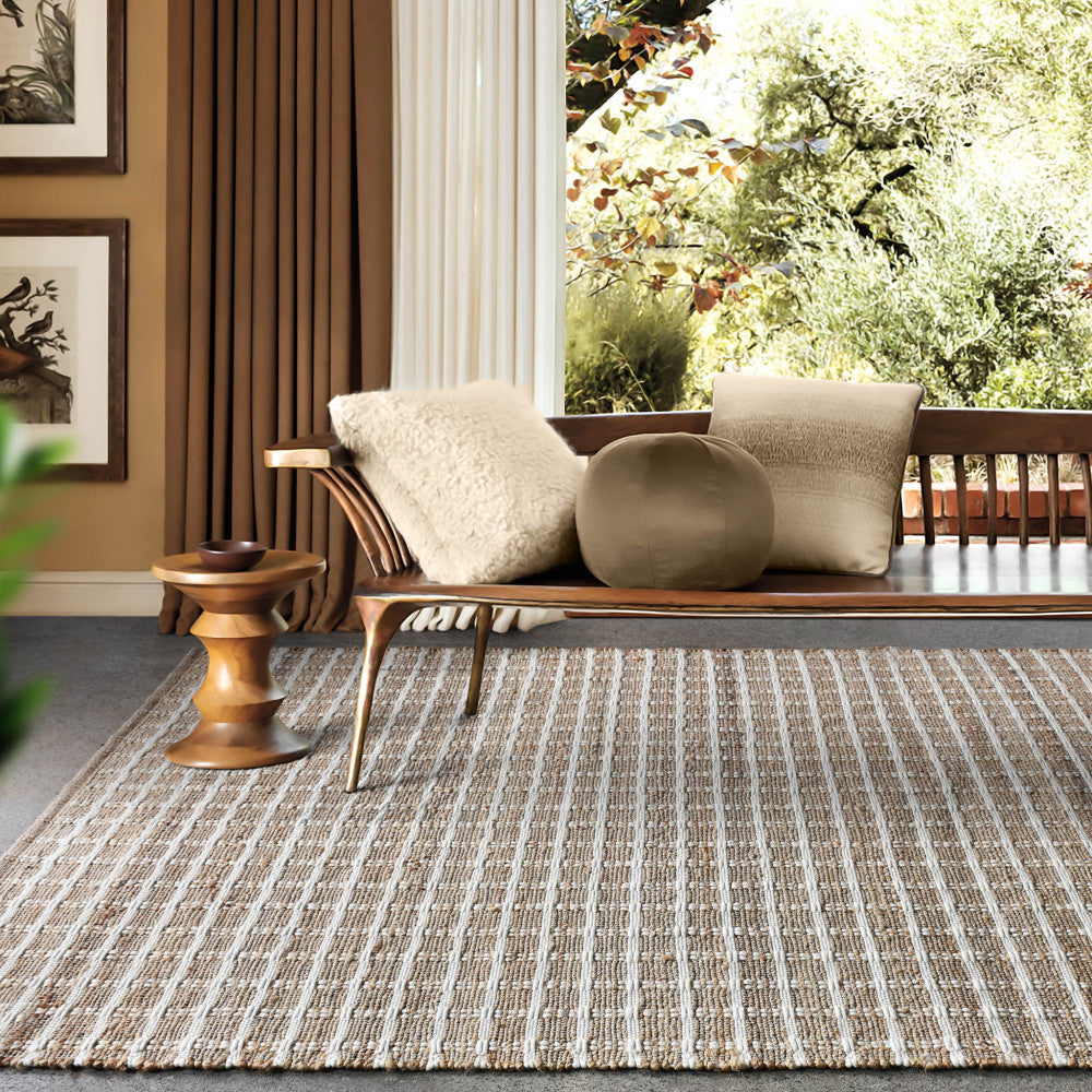 Tappeto Gérard ambientato in un salotto dal sapore organico con panca in legno e cuscini decorativi.
