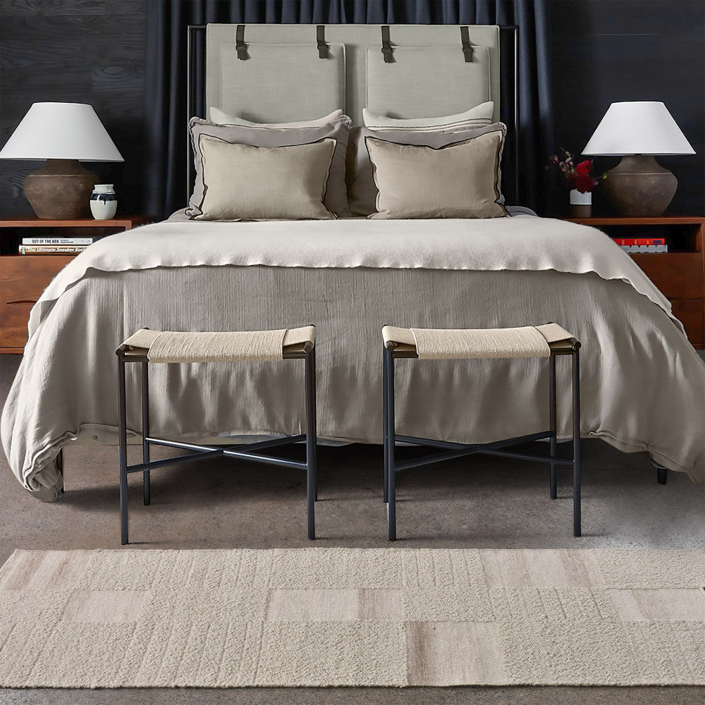 Tappeto Georges beige collocato ai piedi di un letto matrimoniale in una camera da letto dal design sofisticato.