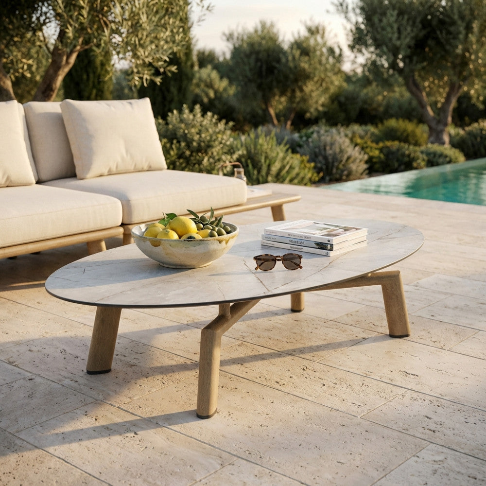 Tavolino moderno in laminato con ciotola di limoni e occhiali da sole in un patio esterno.