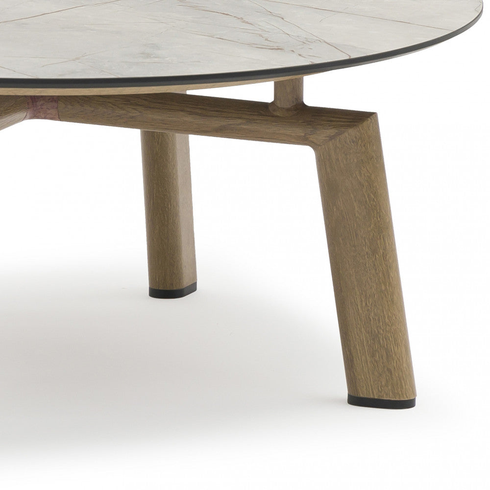 Dettaglio ravvicinato della gamba in legno e del bordo sottile del piano in laminato grigio.
