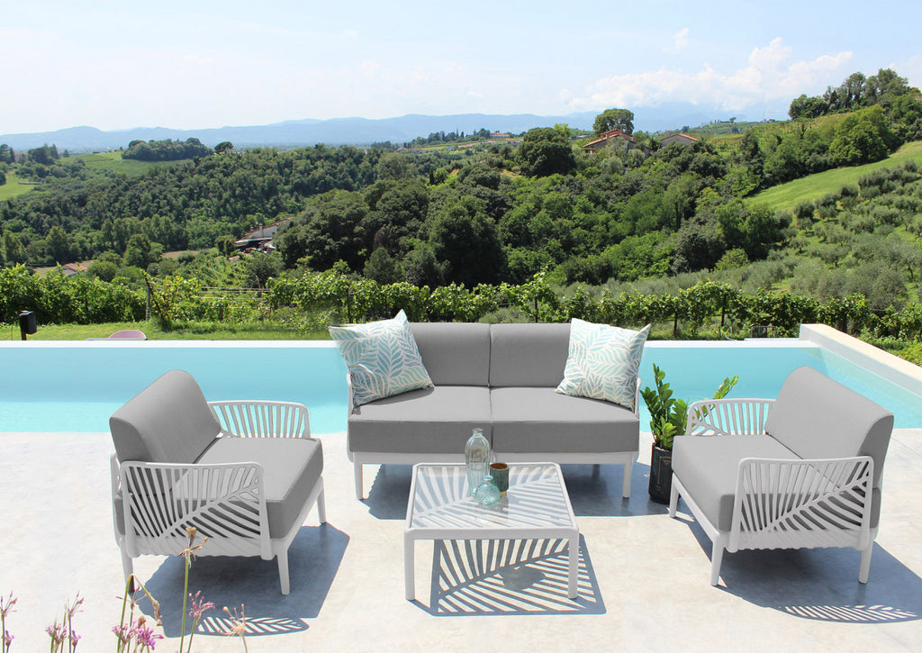 Set da esterni con il tavolino Guaranà e divani grigi, posizionato su una terrazza con vista panoramica sul verde.