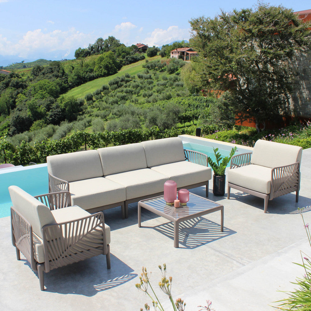 Set lounge completo all'aperto con il tavolino Guaranà al centro, circondato da divani e poltrone in corda intrecciata.